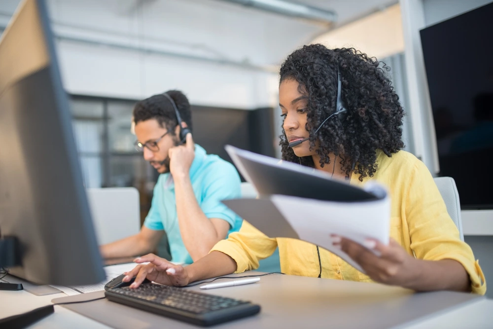 Two-customer-service-representatives-working-at-their-desks